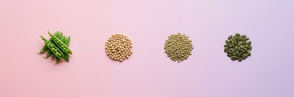 Nutrición enteral con proteína vegetal: tolerancia digestiva a dos semanas 1 Guisantes en vaina, garbanzos, lentejas y pipas de calabaza sobre fondo pastel
